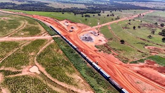 Vista aérea de um canteiro de obras com um trem passando.