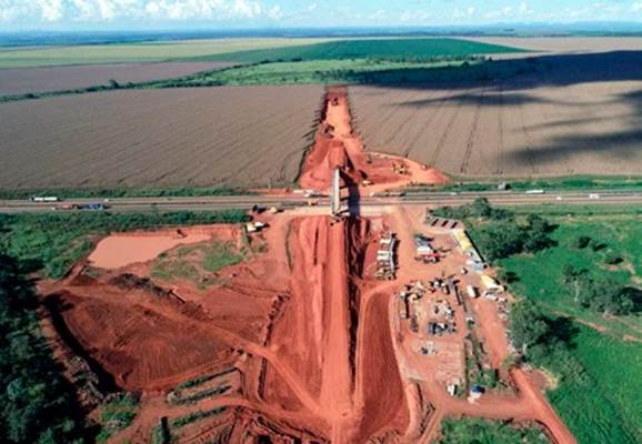 Vista aérea de um canteiro de obras com uma ponte em construção.